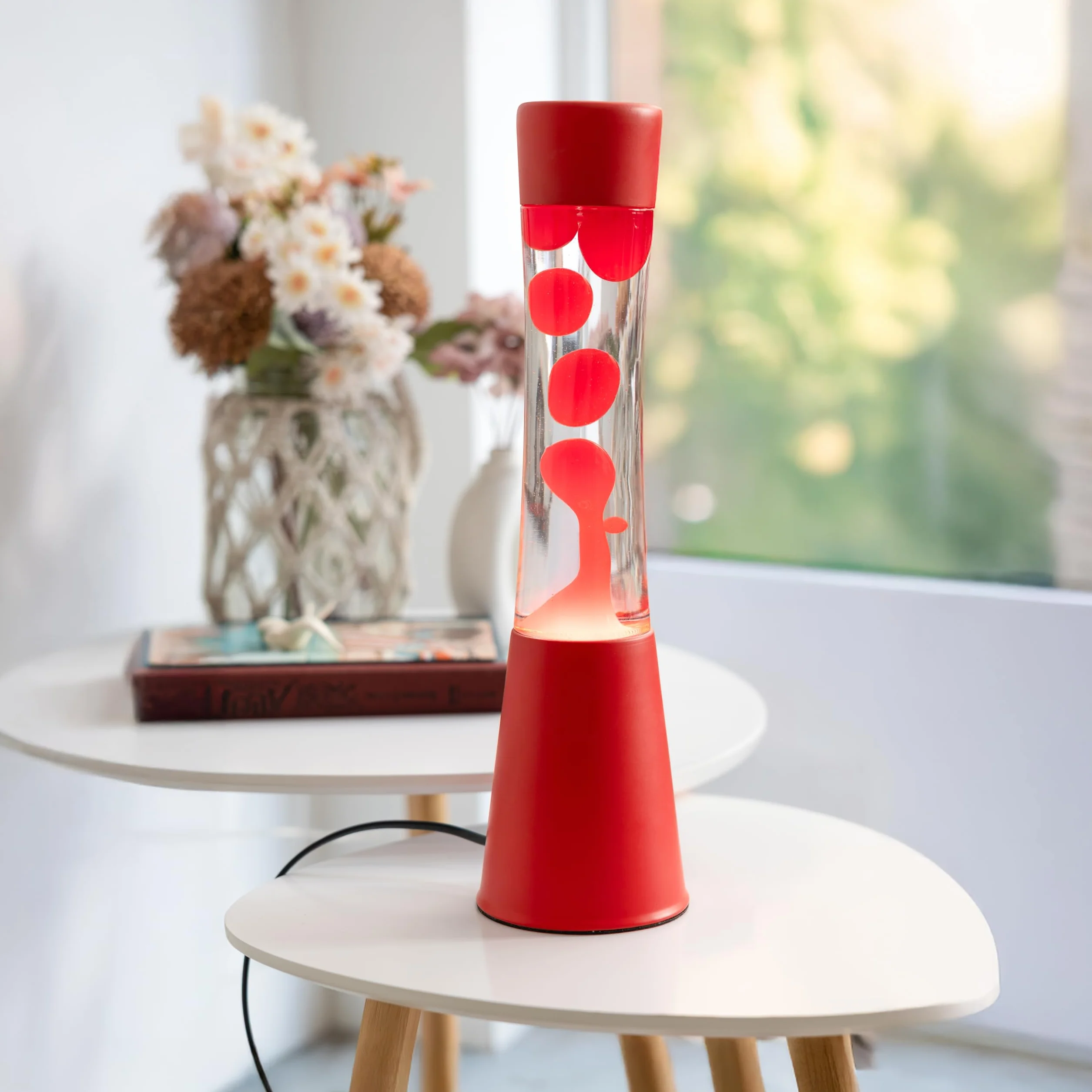 Fisura – Lampa z lawą czerwona. Podstawa i lawa w kolorze czerwonym z przezroczystym płynem. Lampa relaksacyjna z zapasową żarówką. 11 cm x 11 cm x 39,5 cm.