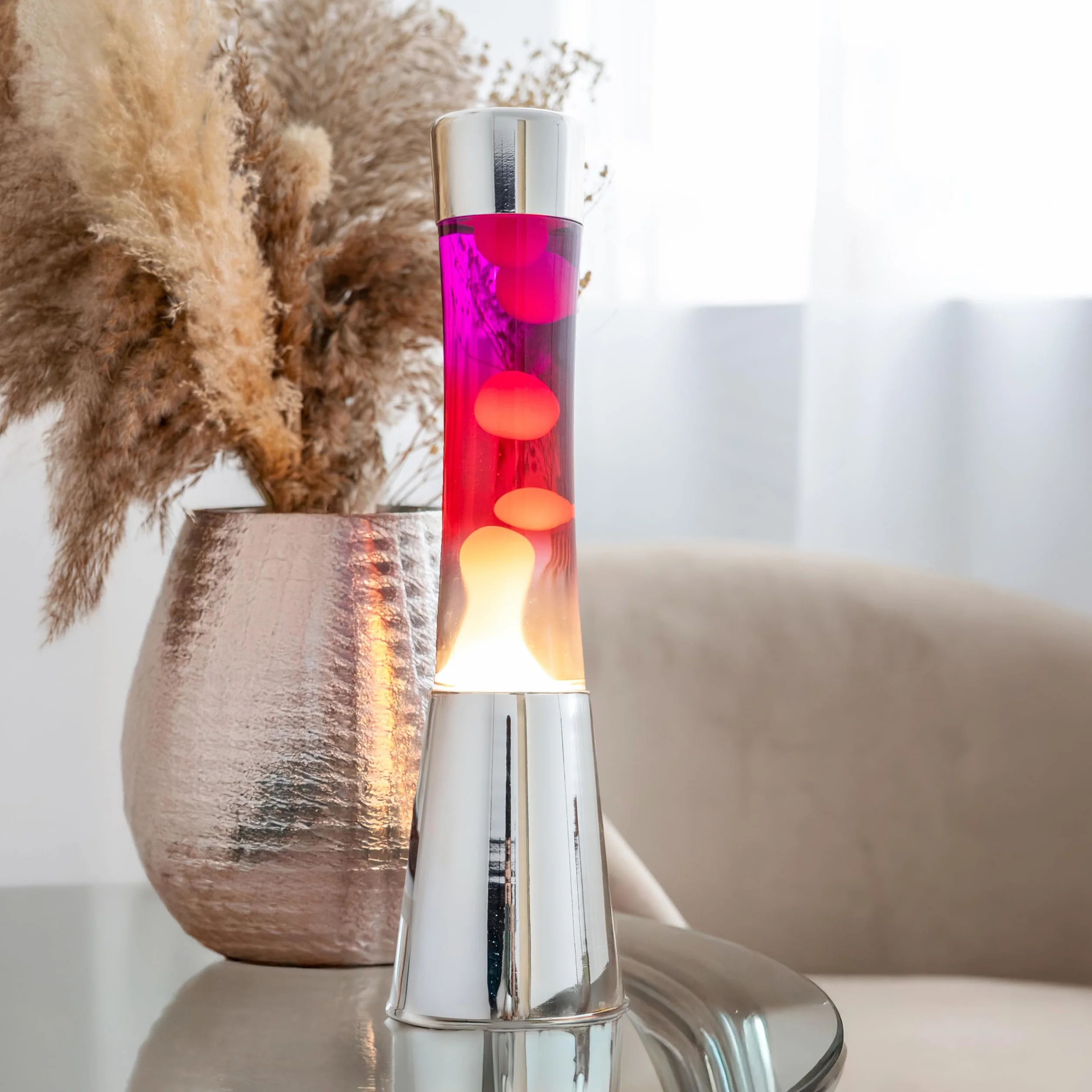 Fisura – Lampa z lawą „gradient czerwony”. Podstawa chromowana, butelka z efektem przejścia od fioletowego do białego. Lampa relaksacyjna z zapasową żarówką. 11 cm x 11 cm x 39,5 cm.