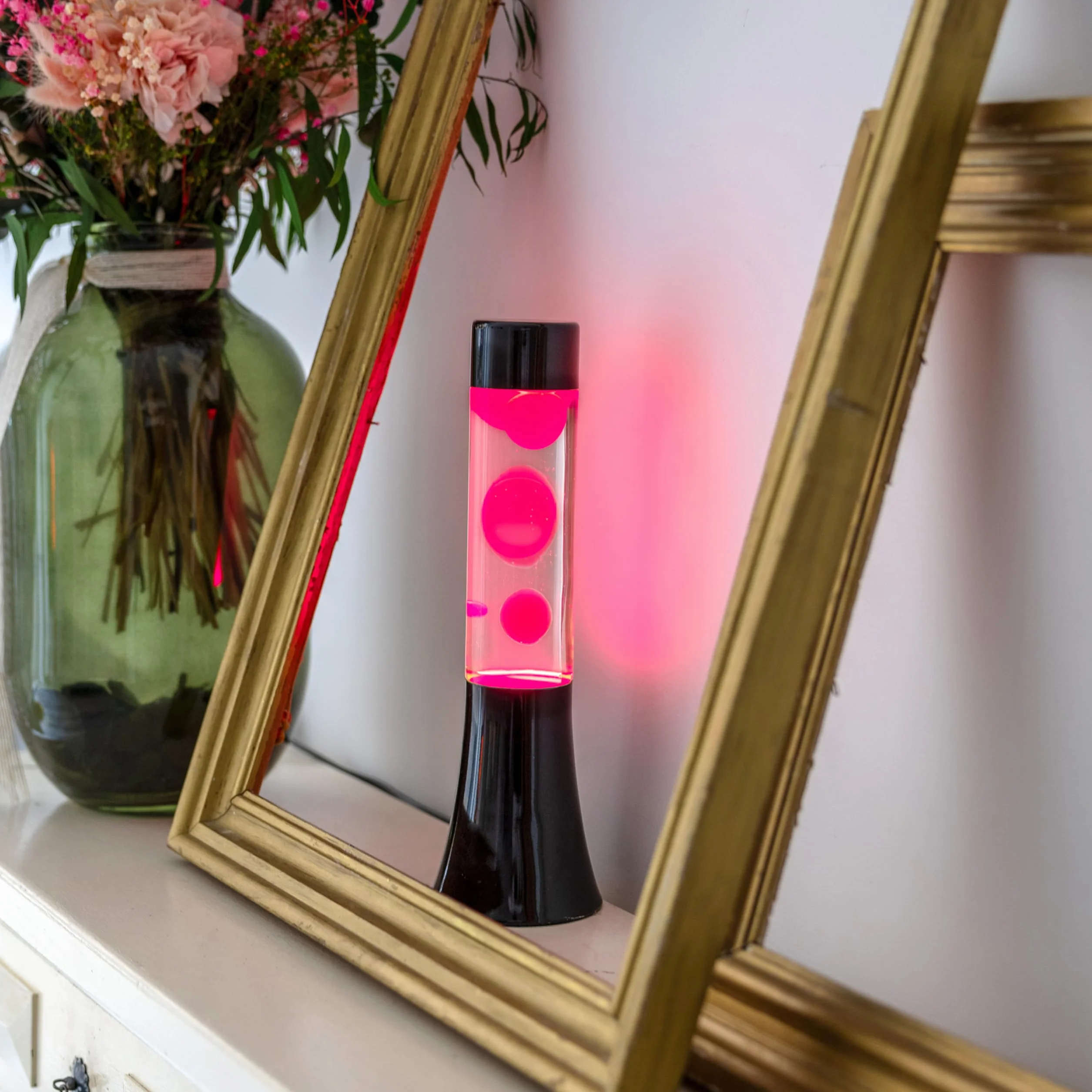 Fisura - Różowa lampa lawa. Lampa lawa o wysokości 30 cm z czarną podstawą, różową lawą i przezroczystym płynem. Relaksująca lampa. 9x9x30 cm