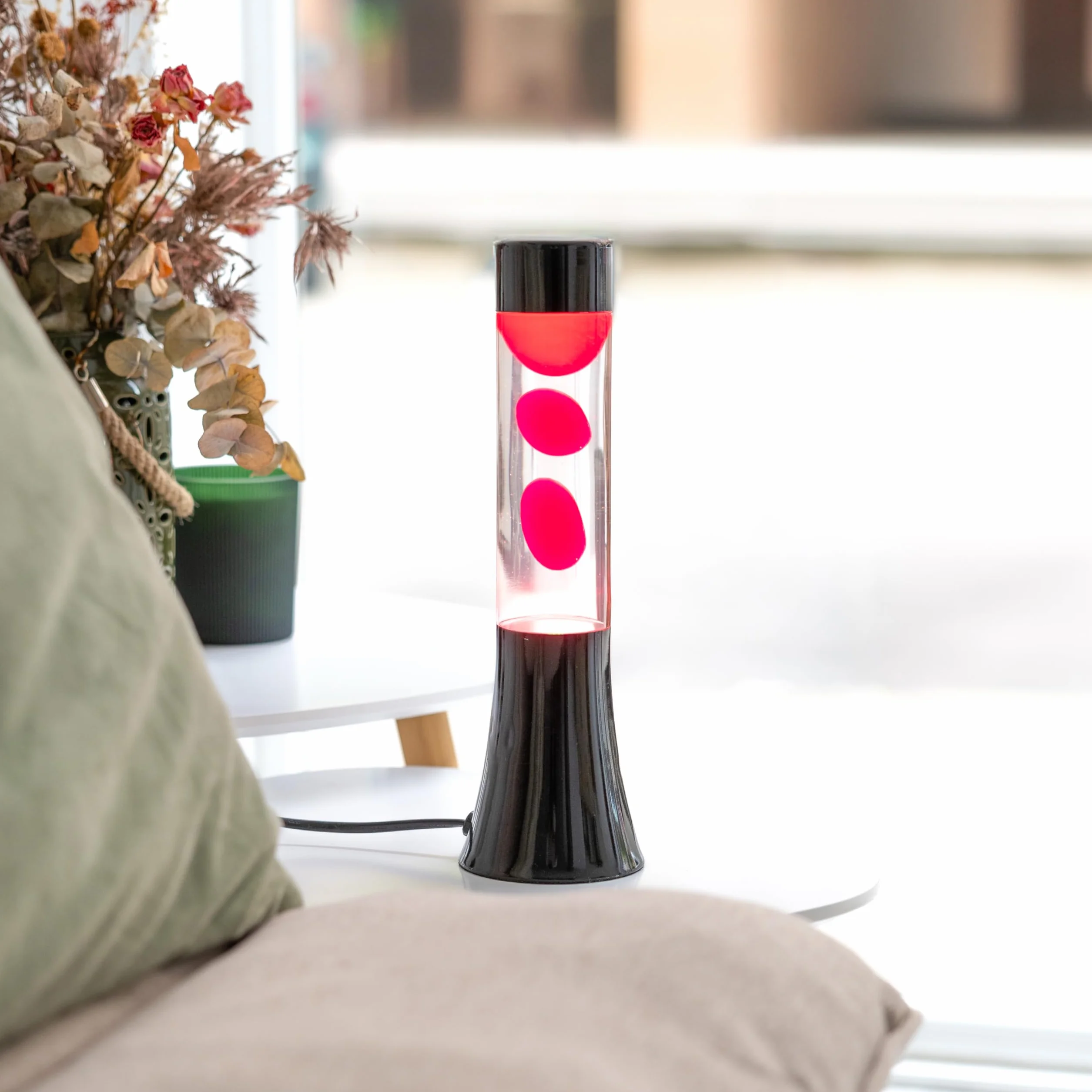 Fisura - Różowa lampa lawa. Lampa lawa o wysokości 30 cm z czarną podstawą, różową lawą i przezroczystym płynem. Relaksująca lampa. 9x9x30 cm
