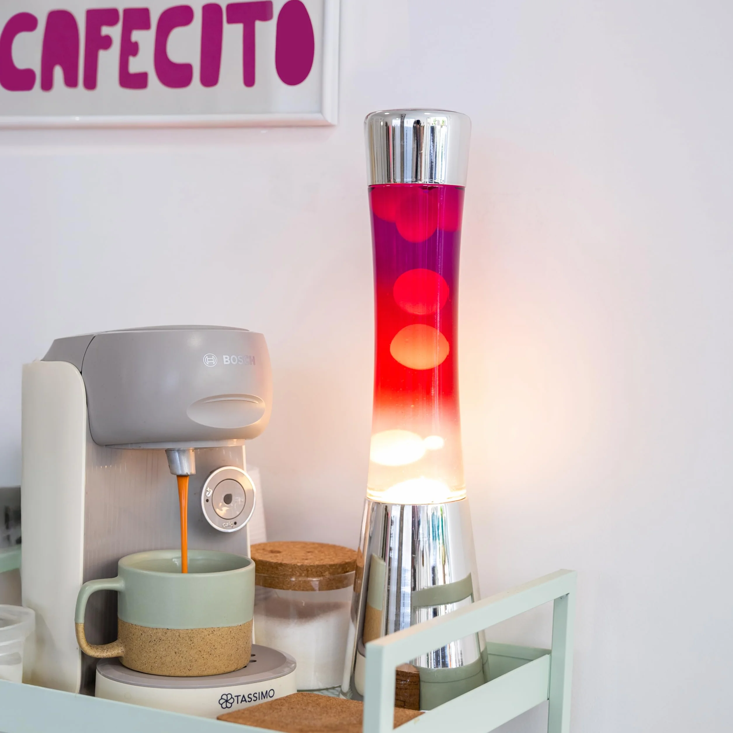 Fisura – Lampa z lawą „gradient czerwony”. Podstawa chromowana, butelka z efektem przejścia od fioletowego do białego. Lampa relaksacyjna z zapasową żarówką. 11 cm x 11 cm x 39,5 cm.
