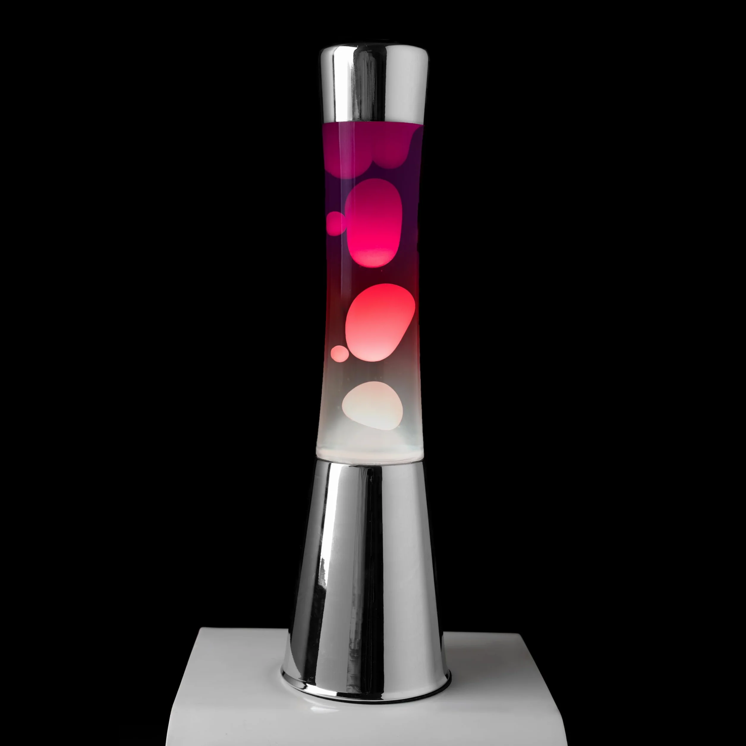 Fisura – Lampa z lawą „gradient czerwony”. Podstawa chromowana, butelka z efektem przejścia od fioletowego do białego. Lampa relaksacyjna z zapasową żarówką. 11 cm x 11 cm x 39,5 cm.