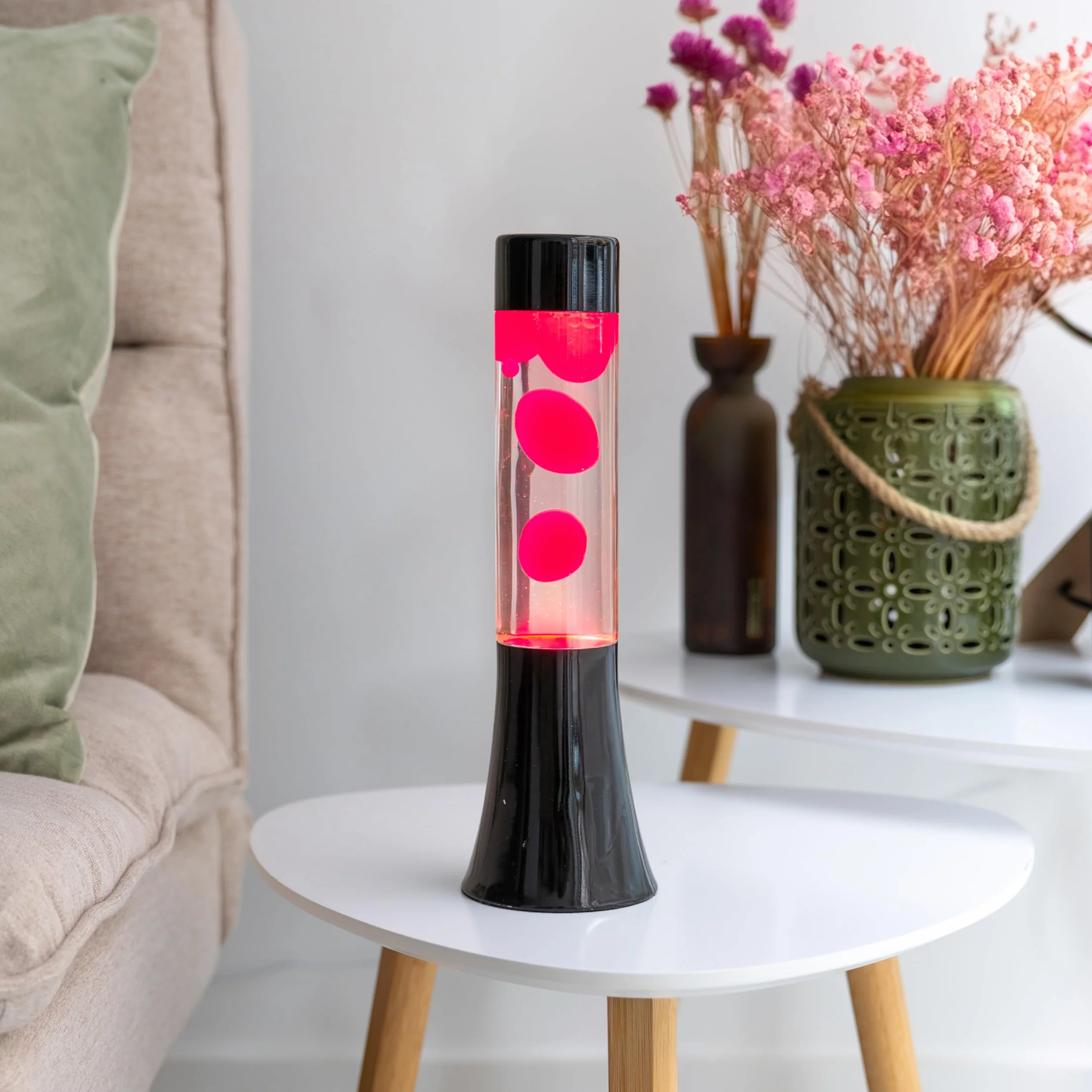 Fisura - Różowa lampa lawa. Lampa lawa o wysokości 30 cm z czarną podstawą, różową lawą i przezroczystym płynem. Relaksująca lampa. 9x9x30 cm